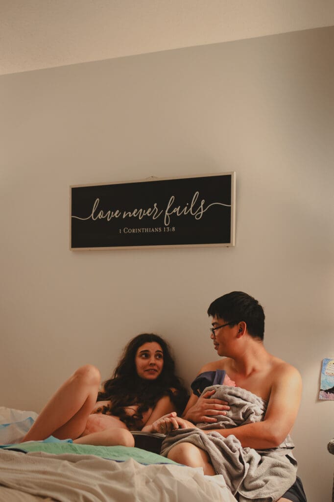 Mother, newborn, and partner resting after a home birth in how to have a positive birth experience, Tifton birth photography