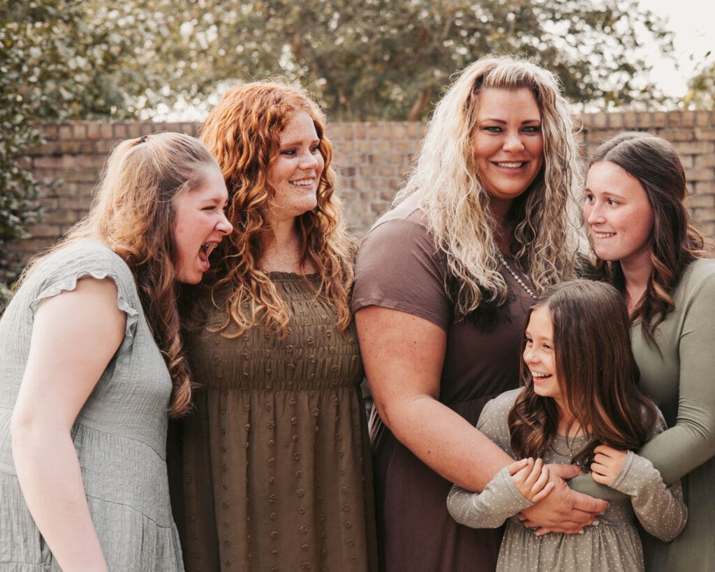 Finding balance in motherhood: Photo of a mother with her four daughters, laughing expressively, by Tifton photographer