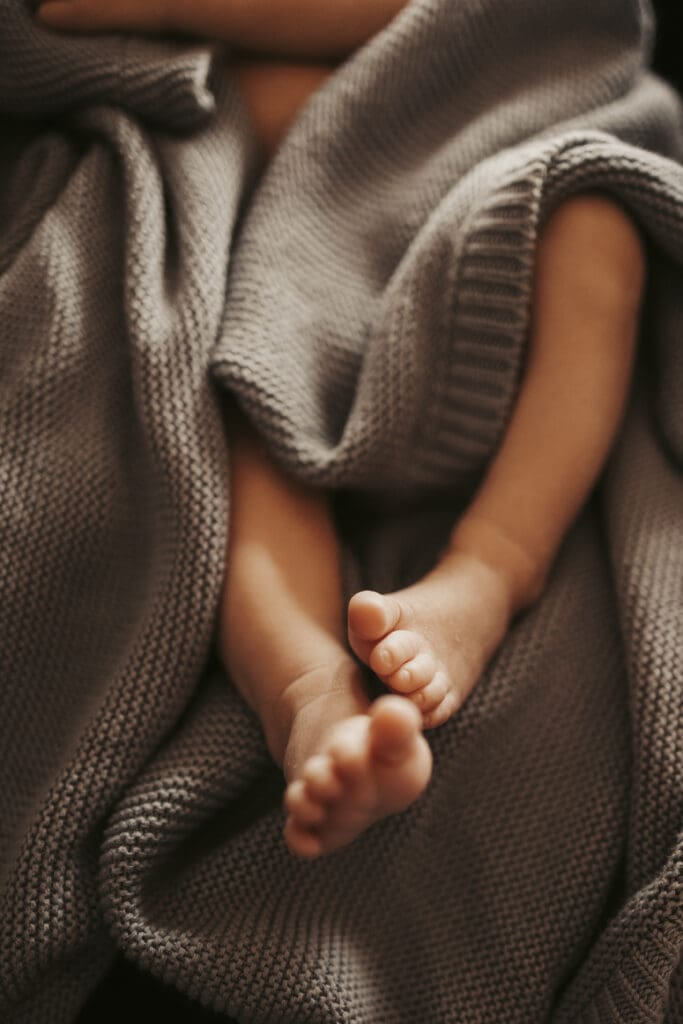 Newborn baby resting quietly in a soft blanket during early postpartum days—postpartum mental health