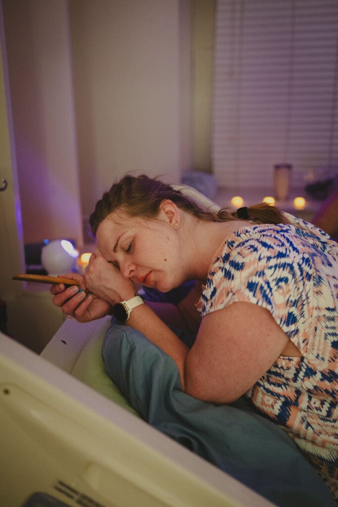 Pregnant woman resting quietly between contractions, holding a birth comb, eyes closed reflecting the mental side of labor—by Tifton doula and birth photographer Sarah John Photography