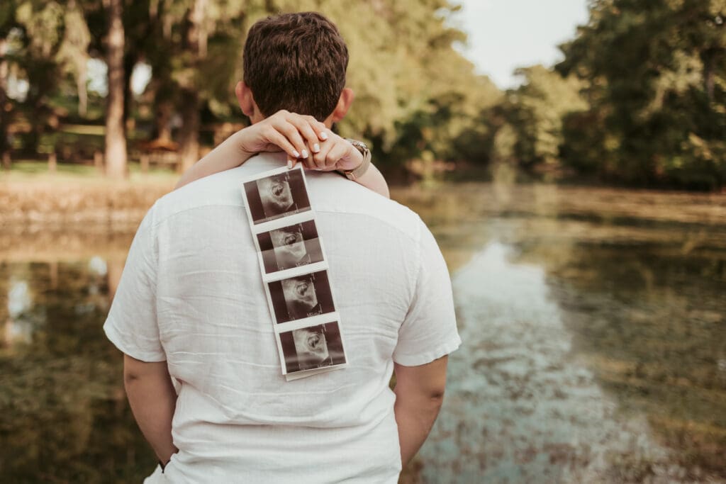 Expectant parents holding ultrasound photos during early pregnancy session in Tifton, Georgia