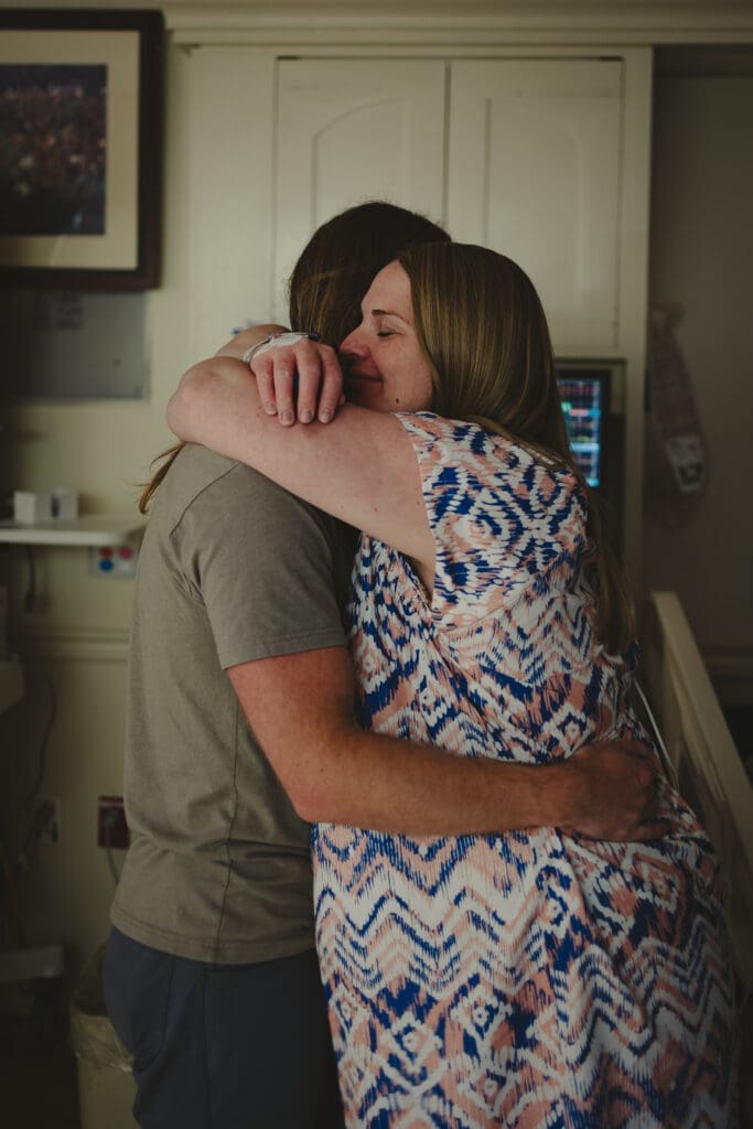 Laboring mother receiving emotional support from her partner during hospital birth in Albany, GA by birth photographer